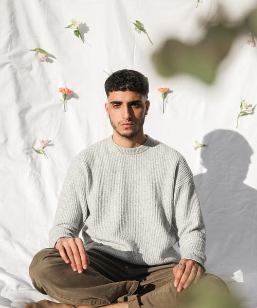 Silhouette of a person in a balanced, calm pose against a pink background.